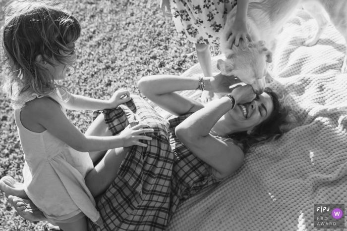 Family documentary photography in Israel during a session with a mom playing with her children and the dog