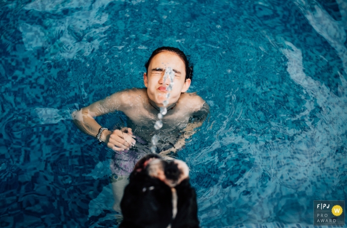 Gezinsdocumentairefotografie in Mexico-Stad voor een kind in het zwembad dat met water speelt en een hond