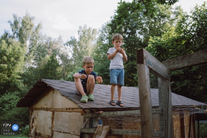 Photojournalisme familial documentaire de Tallinn, Estonie avec des enfants enjoués sur le toit du poulailler