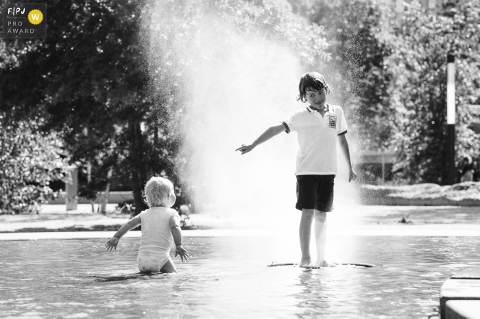 Tournage de photographie de famille documentaire à Amsterdam en enregistrement BW Deux frères s'amusant dans une fontaine