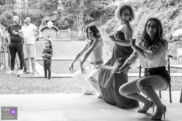 BW documentary family photojournalism from Sao Paulo showing party guests dancing on a patio BW documentary family photojournalism from Sao Paulo showing party guests dancing on a patio