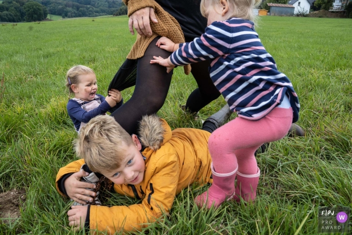 kids tugging at mom on the grass lawn North Rhine-Westphalia kids tugging at mom on the grass lawn of Dusseldorf