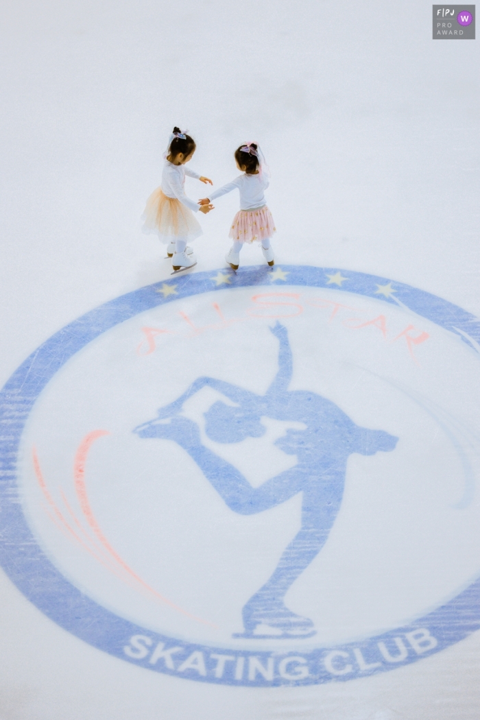 sisters are ice skating on a rink with matching outfits Zhejiang Sisters are ice skating on a rink with matching outfits