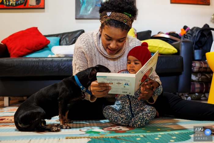 Een hond van Minas Gerais die aandachtig deelneemt aan het lezen van het boek met de baby