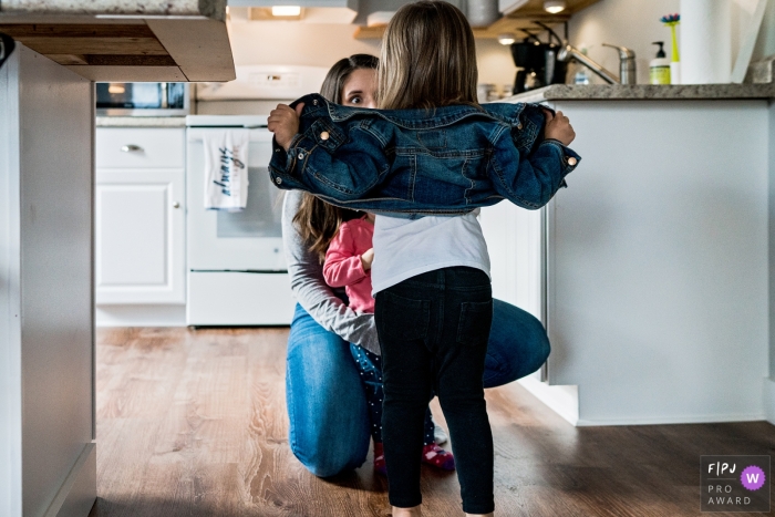 little girl opens up her jean jacket while mom's eyes go wide A New Hampshire United States little girl opens up her jean jacket while mom's eyes go wide