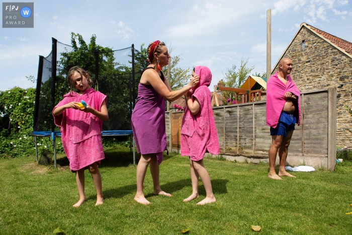 Family drying off with pink towels after a swim during a family documentary session near Bristol, UK