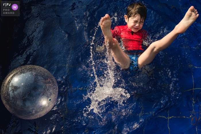 A Campo Grande boy plays with legs and water in the air	