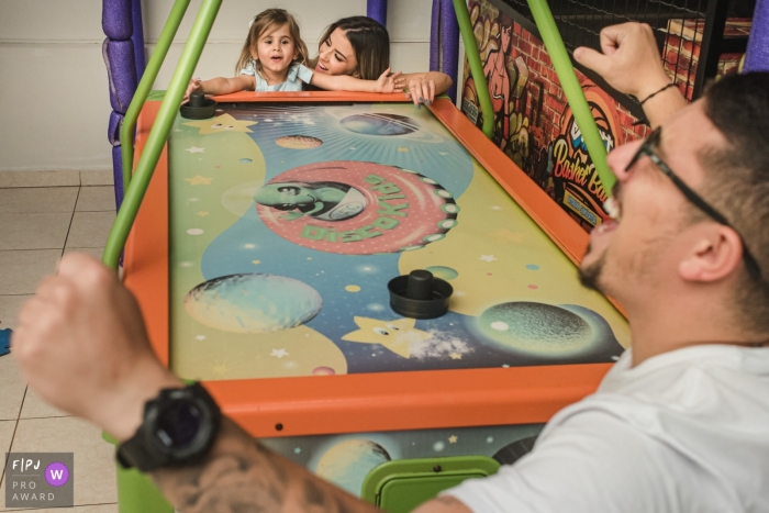 girl playing air hockey with uncle who scored a goal Campo Grande girl playing air hockey with uncle who scored a goal in Mato Grosso do Sul