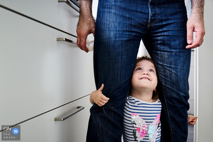 little girl is smiling at her dad and waiting for her baby bottle at home A North Rhine-Westphalia little girl is smiling at her dad and waiting for her baby bottle at home in Bonn