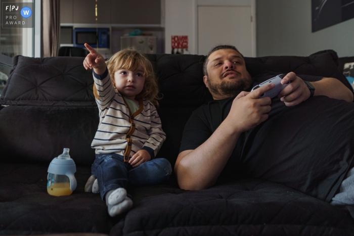 dad and son playing video games together at home on the couch Sao Paulo dad and son playing video games together at home on the couch