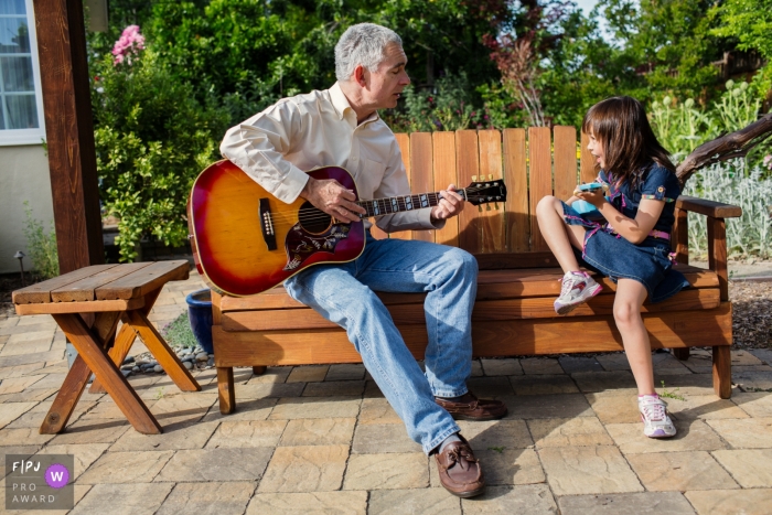 A Happy CA dad and daughter moment of guitar jamming outside on the patio in San Francisco