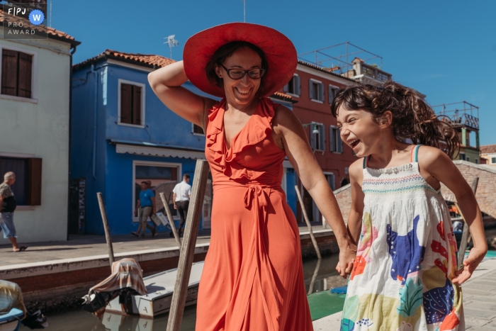 Maman et sa fille marchant joyeusement autour des canaux de l'île de Burano (Venise) par une chaude journée d'été