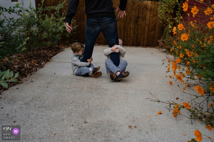 dad gives his boys a ride on the driveway near flowers at a home An Atlanta dad gives his boys a ride on the driveway near flowers at a home in Georgia