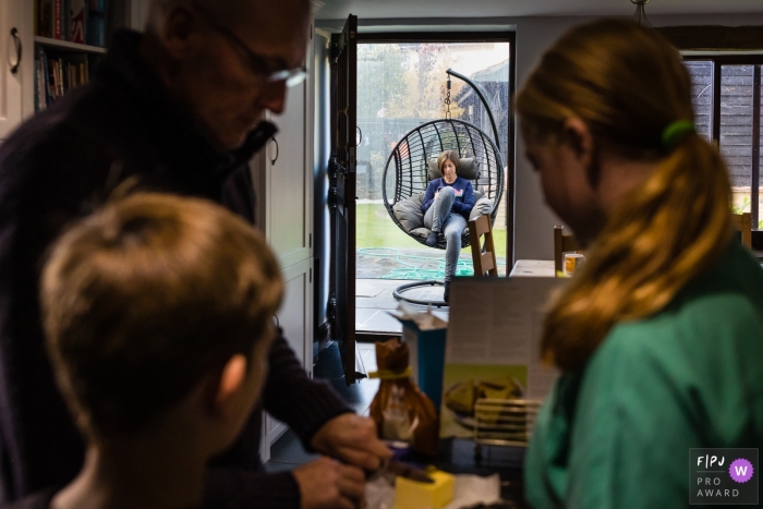 Photo de famille Cambridgeshire montrant papa cuit avec des enfants pendant que maman se repose à l'arrière-plan