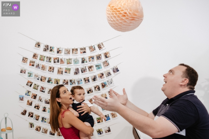 Florianopolis father playing with a ball and son on his birthday and aunt with baby in her lap