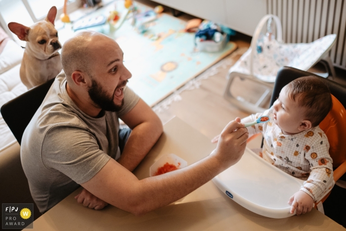 Een St. Catarina-vader die voedsel geeft aan zoon en familiehond die op de achtergrond kijken