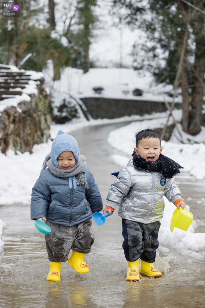 In Hangzhou City, Zhejiang, the brothers joyfully embraced winter snow as they splashed in the water The brothers enjoyed their time together in Hangzhou City, Zhejiang, gleefully splashing in the water with winter snow all around them