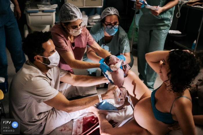 Die Hände des Vaters umfassen sie und die Gefühle der Mutter sind während des Familienfotoshootings vom Samaritan Hospital umgeben