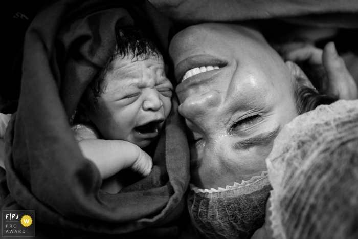 The emotions of the birth, showing the daughter and mother together in that special moment at Maternidade Santa Helena