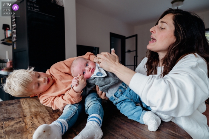 In Amsterdam, a moment is captured when big brother playfully pulls little brother away from their mother