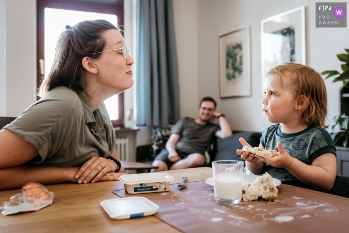 At home, the young family enjoys a meal together A young family is dining at home in Bonn