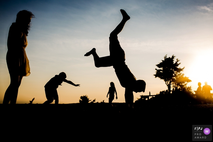 Photographer in New Hampshire captures kids gracefully performing cartwheels against a beautiful sunset backdrop New Hampshire photographer captured a silhouette of kids doing cartwheels at sunset