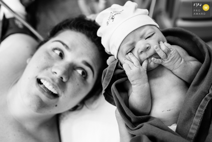 A black and white documentary photograph taken at Maternidade Santa Helena shows a mother and her daughter shortly after birth